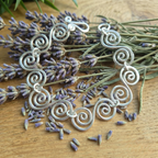 Celtic S silver spiral bracelet lying on some lavender sprigs