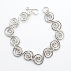 Spiral bracelet with a simple fish hook clasp on a white background