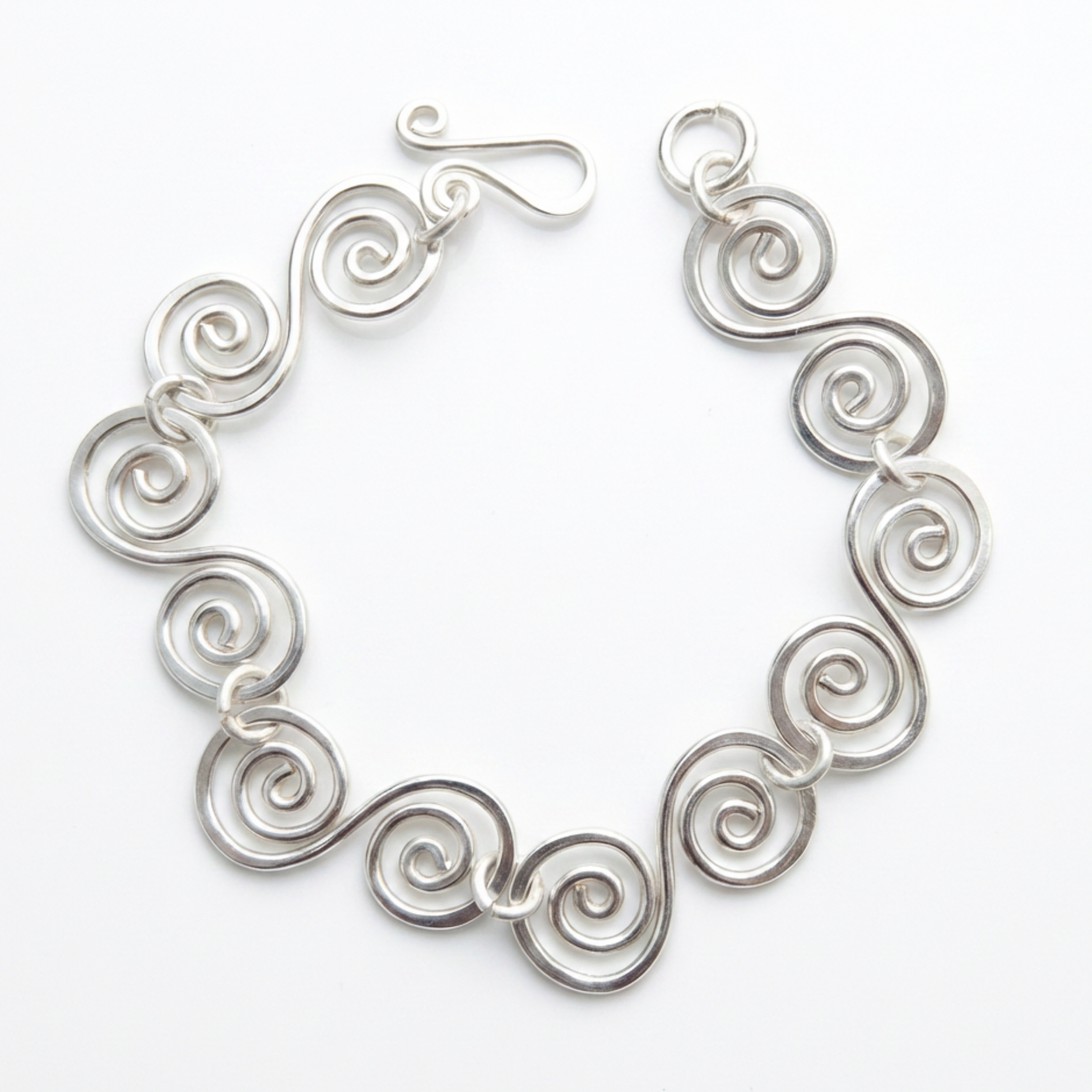 Spiral bracelet with a simple fish hook clasp on a white background