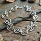 Large statement Celtic Spiral bracelet on slate and wood