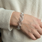 Model wearing a statement Celtic silver spiral bracelet