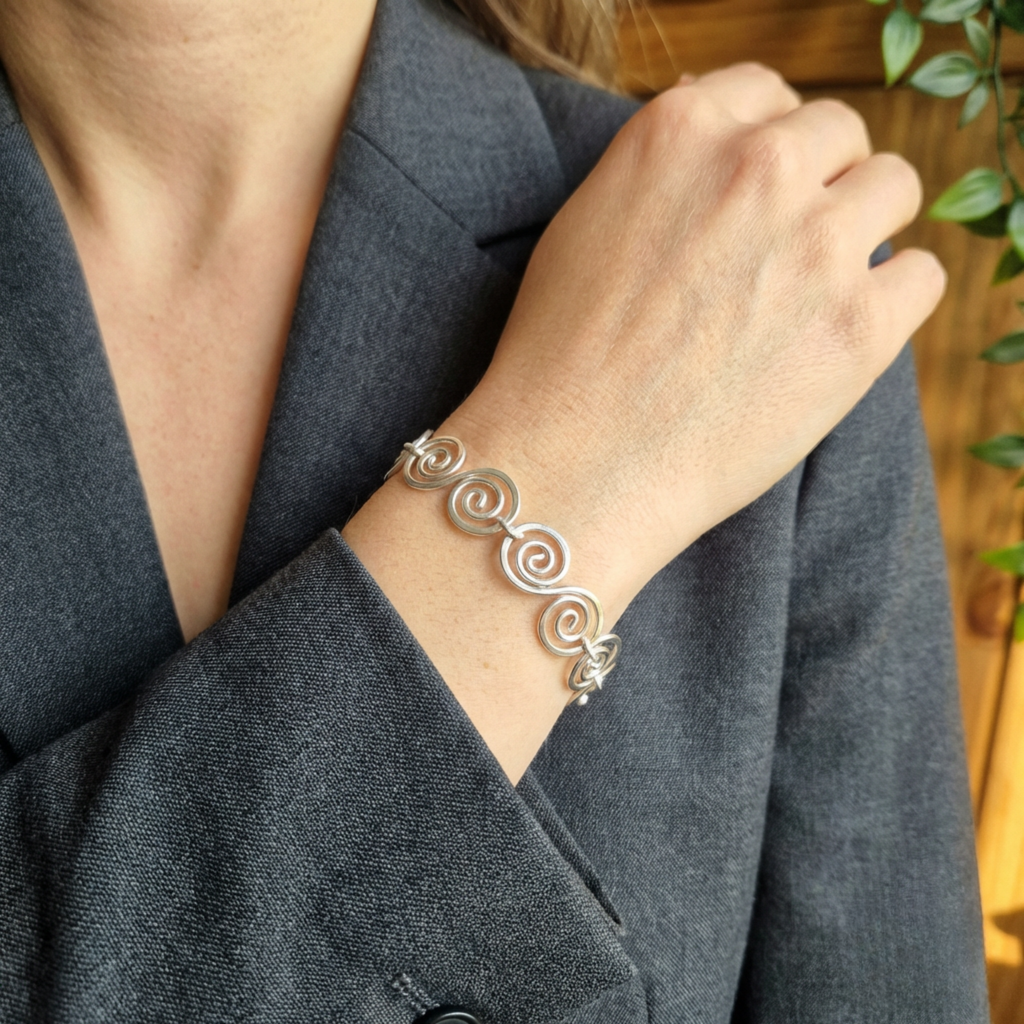Model wearing a grey suit wearing a Celtic silver spiral bracelet