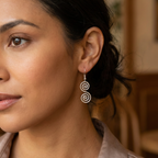 Close-up of a woman wearing spiral earrings with a blurred background
