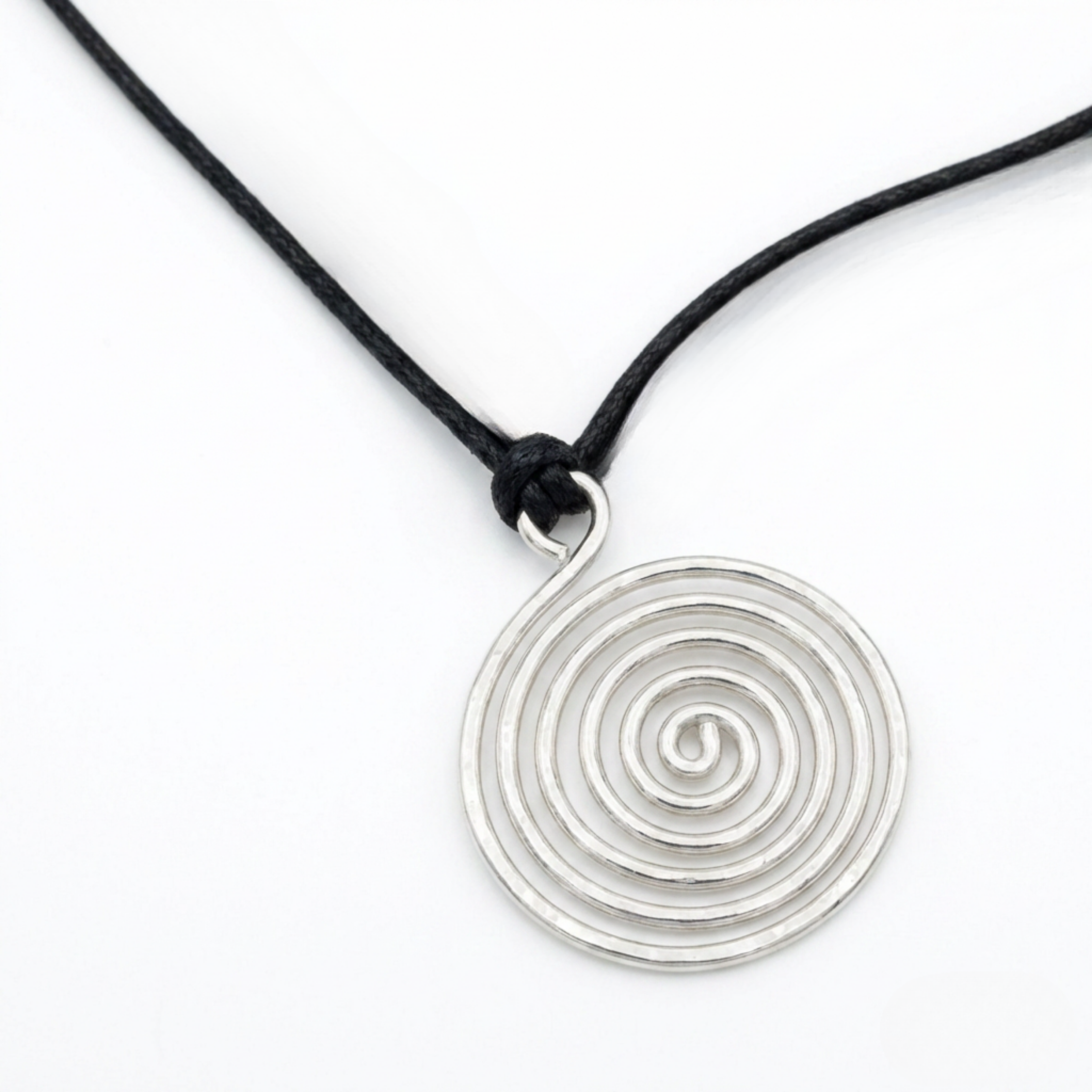 Silver spiral pendant with a black adjustable cord on a white surface