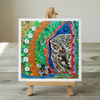 Colourful artwork of an owl on a wooden easel with a wooden surface and light grey background