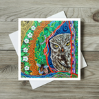 Colourful greeting card with an owl design on a wooden surface