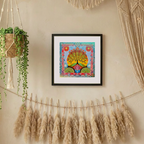 Framed colourful artwork of a tree on a wall with potted plants and decorative strings.