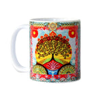 Colourful mug with a tree of life design on a white background
