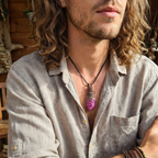 Man wearing a light gray shirt with a necklace featuring a pink stone.
