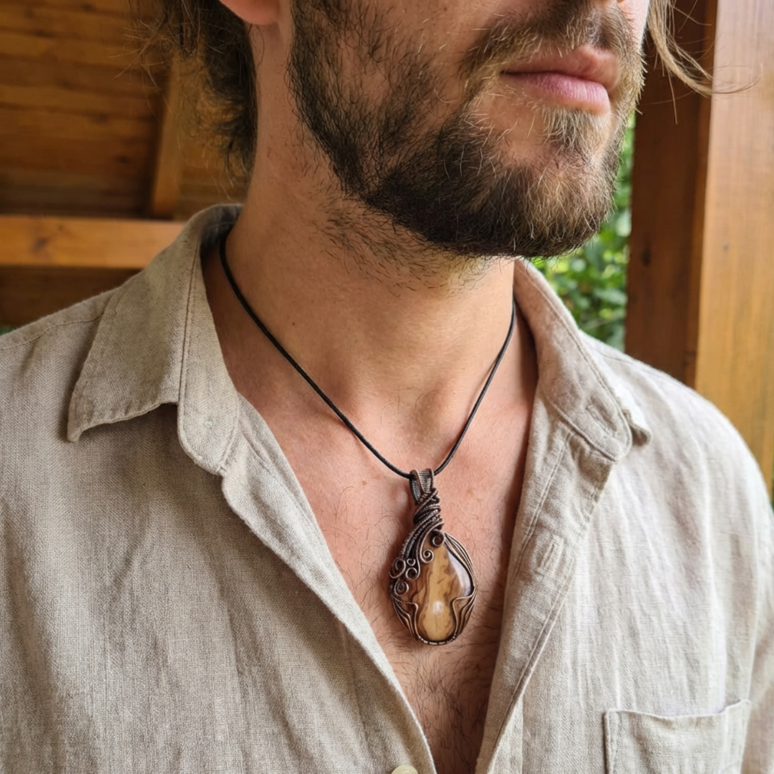 Man wearing a necklace with a large pendant outdoors
