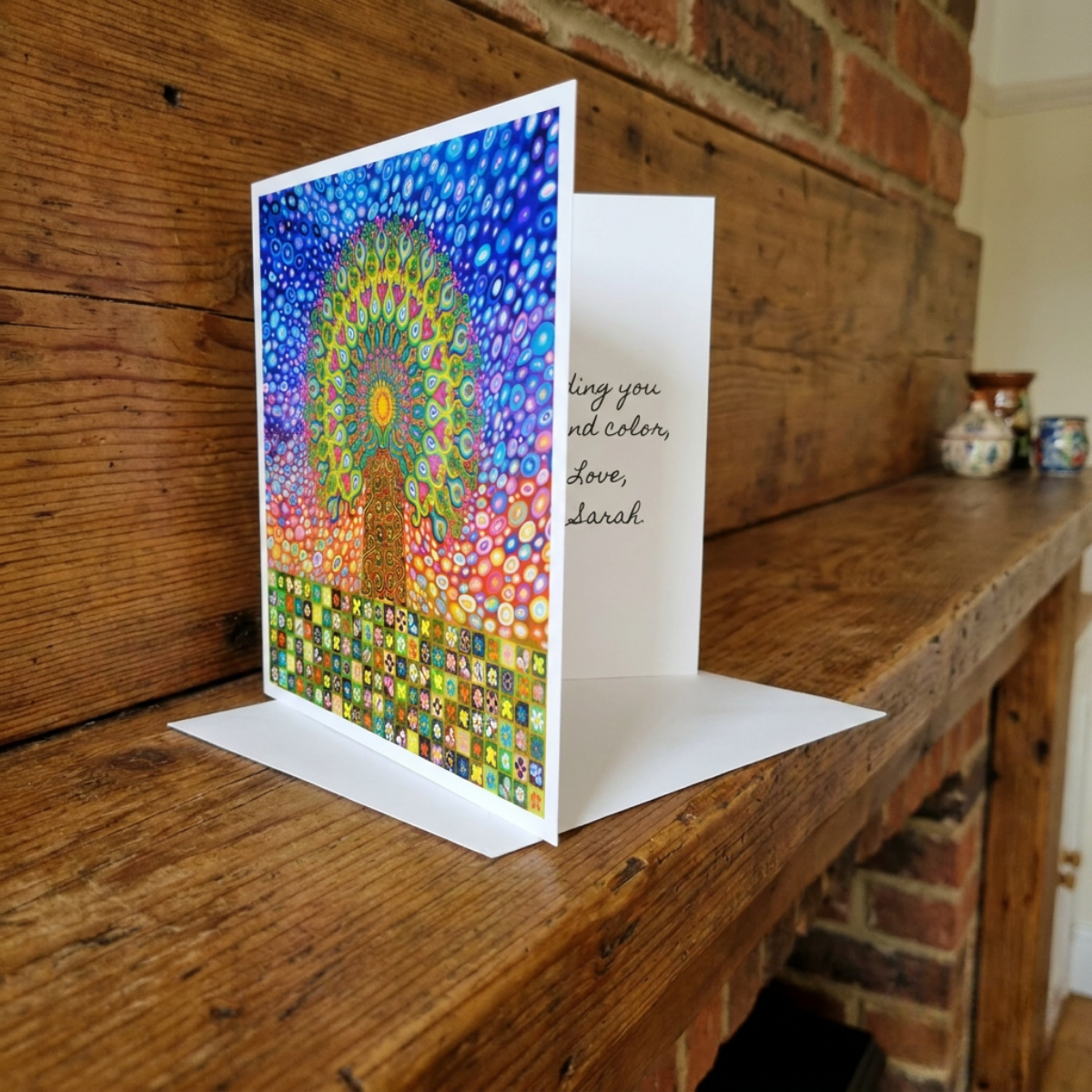 Colourful greeting card with intricate  Mandala Tree of Life design on a wooden surface.