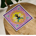 Colorful card with a yoga pose design on a wooden surface