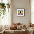 Living room with a colourful framed artwork on the wall, patterned cushions, and a plant.