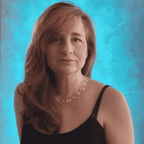 Woman wearing a black top and a open silver spiral necklace against a blue textured background