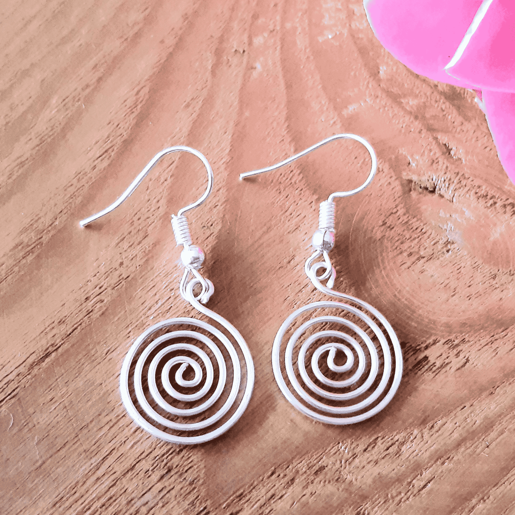 White spiral earrings on a wooden surface