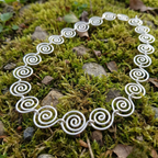 Statement Silver spiral necklace on a mossy surface