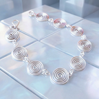 Open silver spiral bracelet flat lay, artisan wire jewellery, Wildform UK