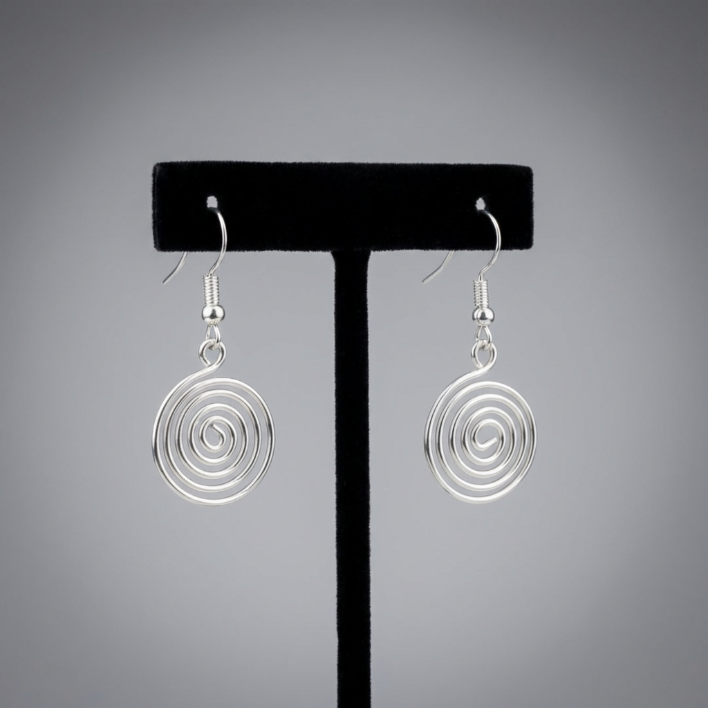 Silver spiral earrings on a black earring stand against a gray background