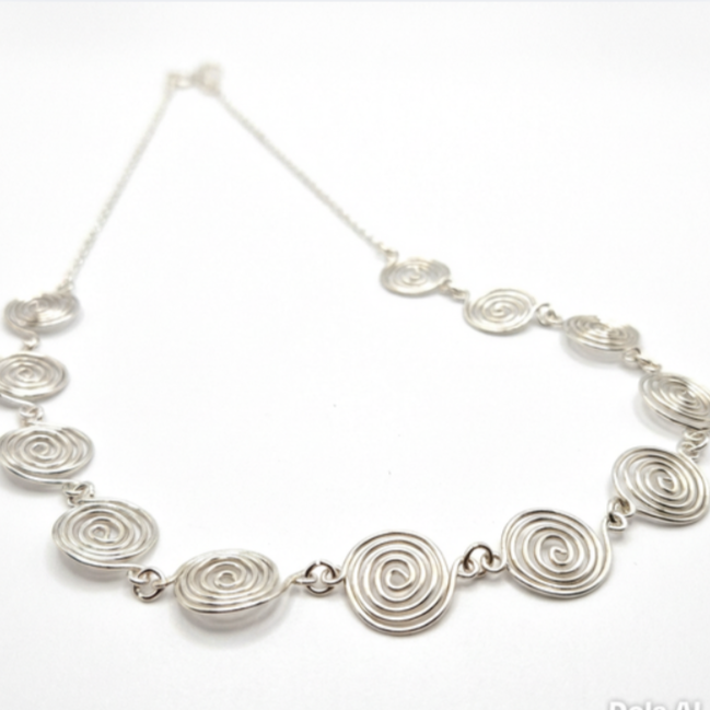 Silver necklace with circular links on a white background
