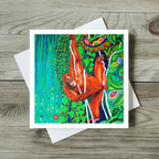 Colourful greeting card with an orange orangutan design on a wooden surface