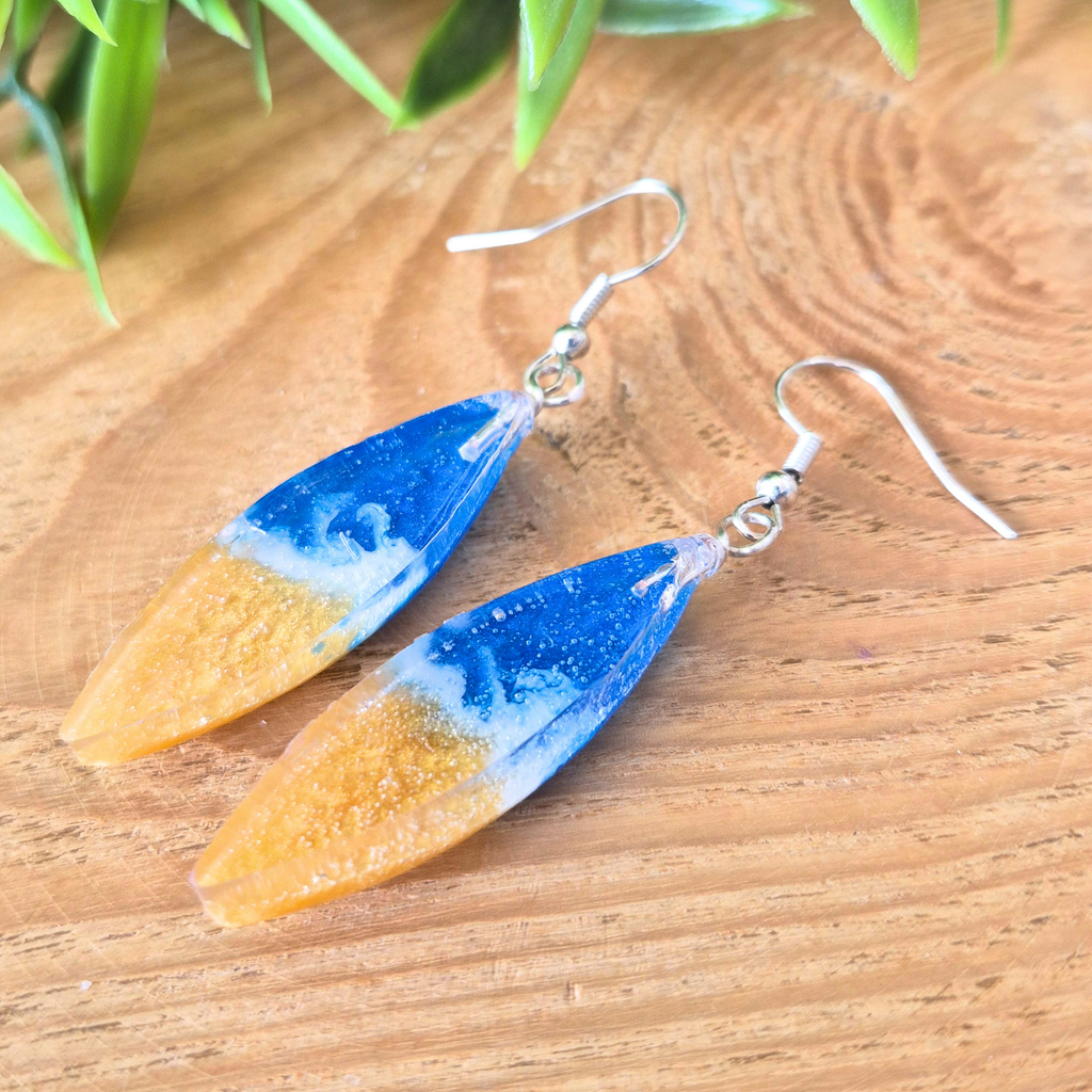 Blue and gold oval earrings with a wave design on ear wires