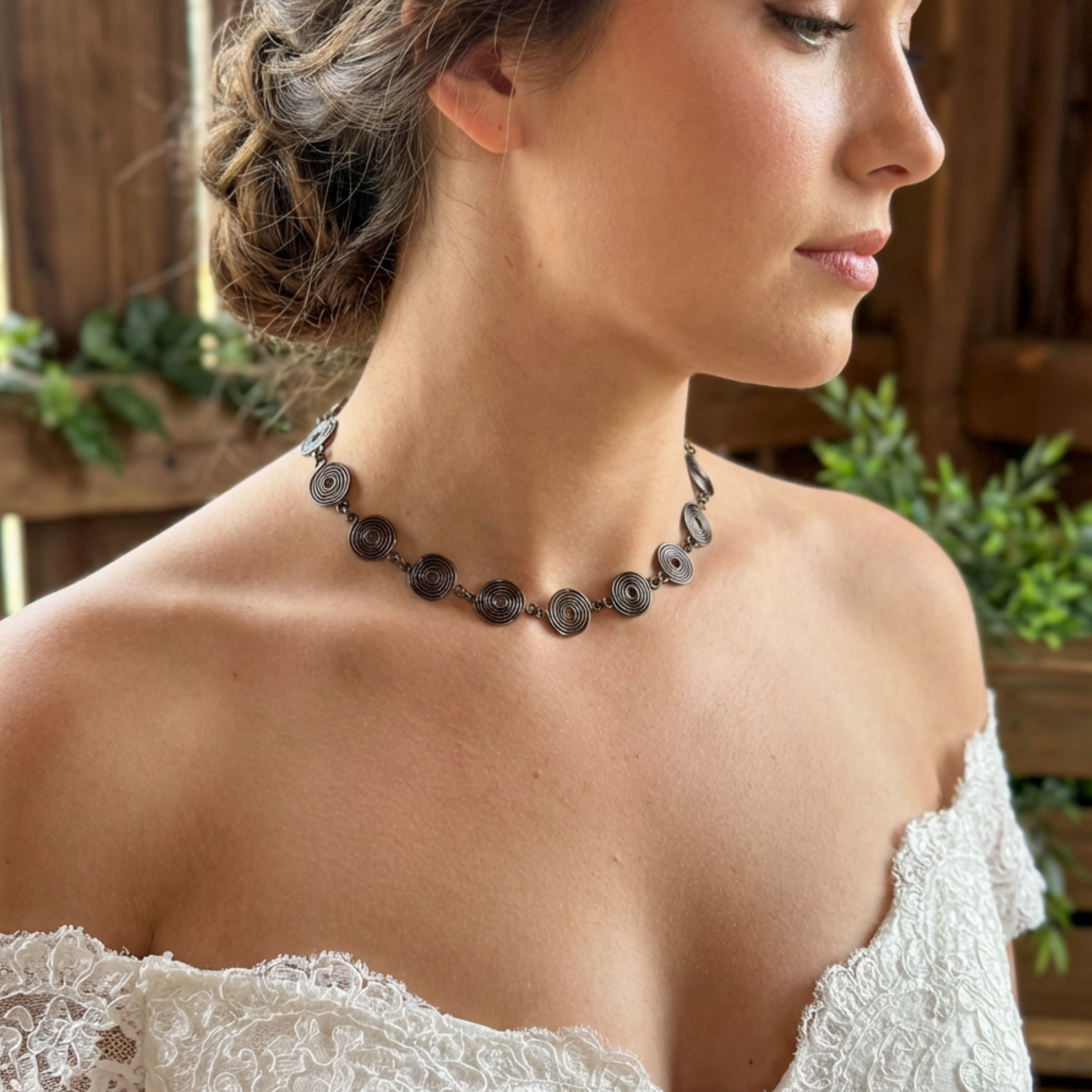 Woman wearing a copper spiral necklace with a blurred natural background