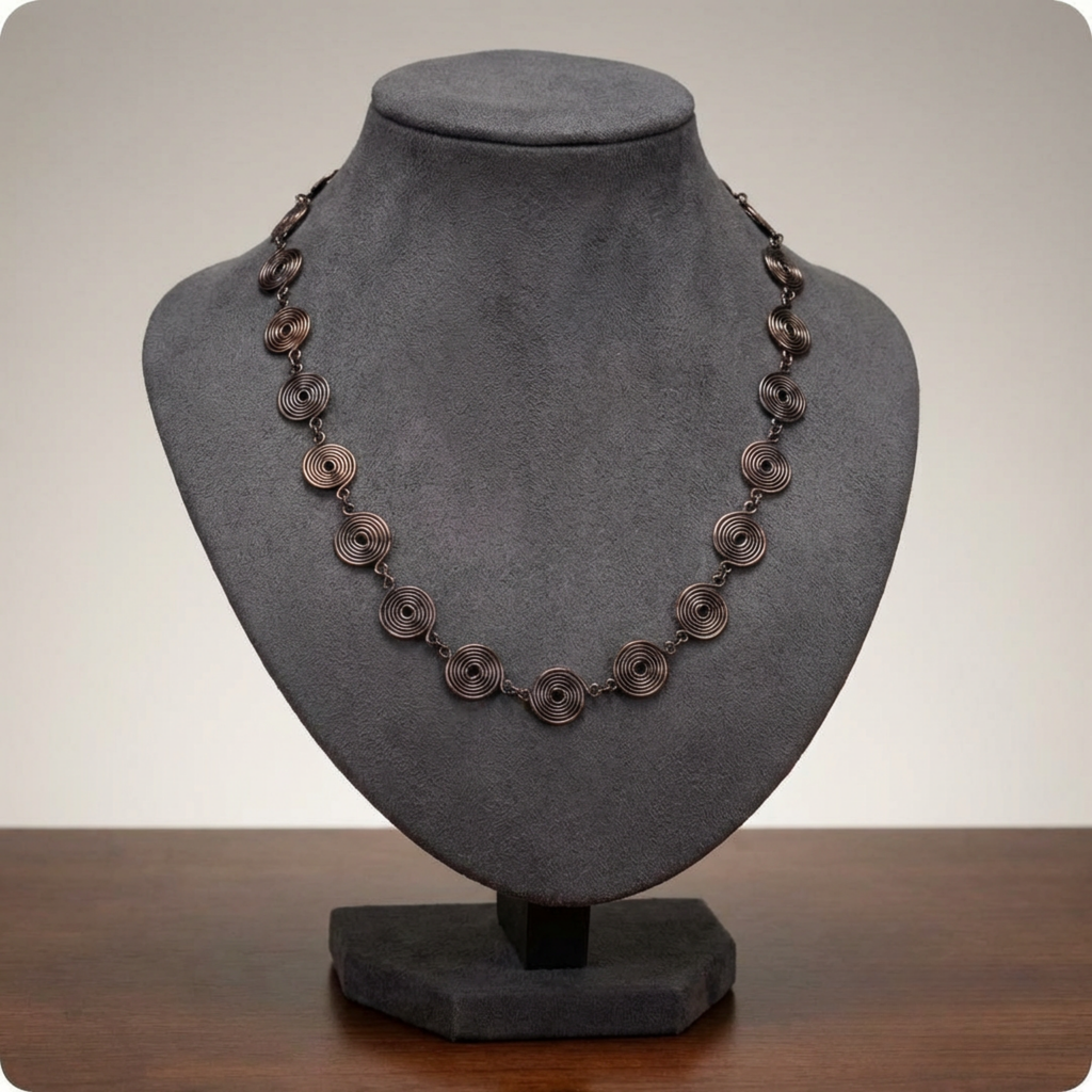 Copper necklace on a grey mannequin bust with a neutral background