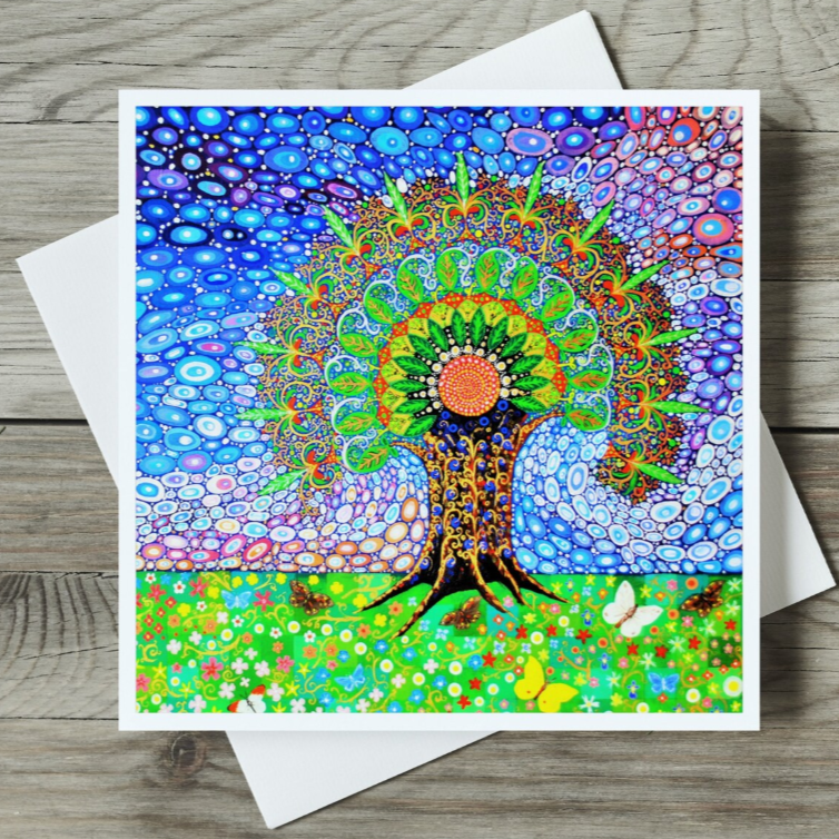 Colourful mandala-style card with a tree of life design on a wooden surface