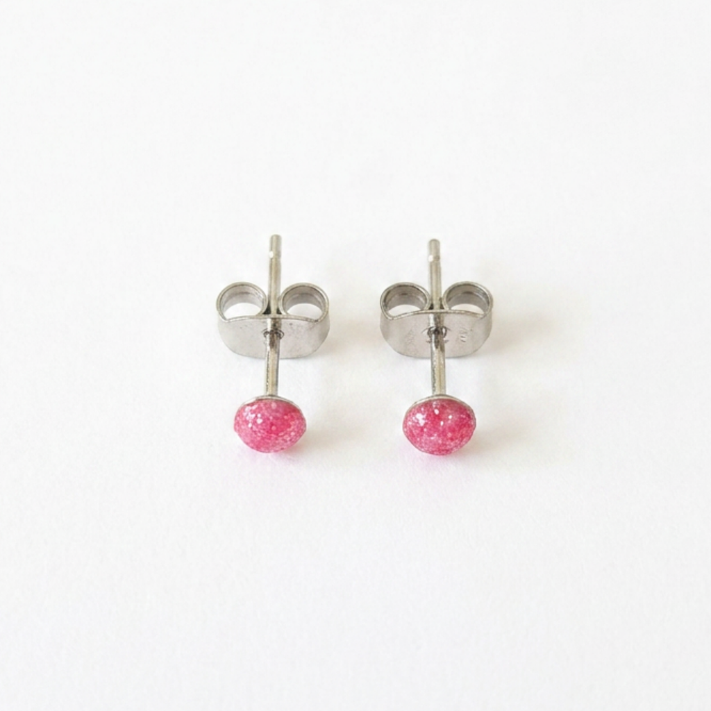 Pair of silver stud earrings with pink centre on a white background