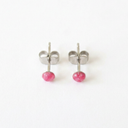Pair of silver stud earrings with pink centre on a white background