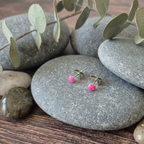 pink dot stud earrings on a stone