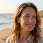 Woman with wavy hair on a beach with ocean in the background