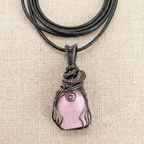 Necklace with a pink pendant on a beige fabric background