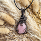Necklace with a pink stone pendant on a fur background