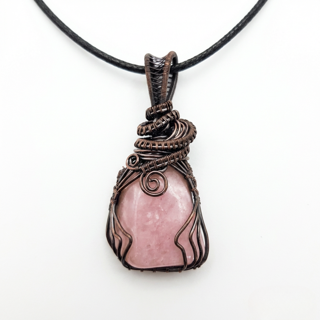 Necklace with a pink stone pendant wrapped in brown wire on a white background
