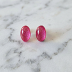 Pink glittery earrings on a marble surface