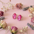 Pink earrings on a pink surface with flowers