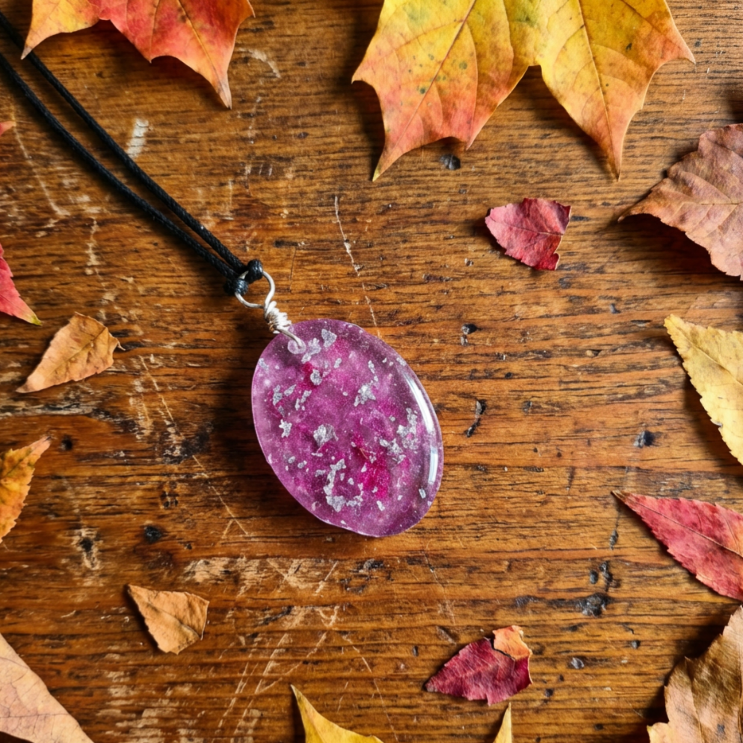 Purple pendant on a wooden surface with autumn leaves