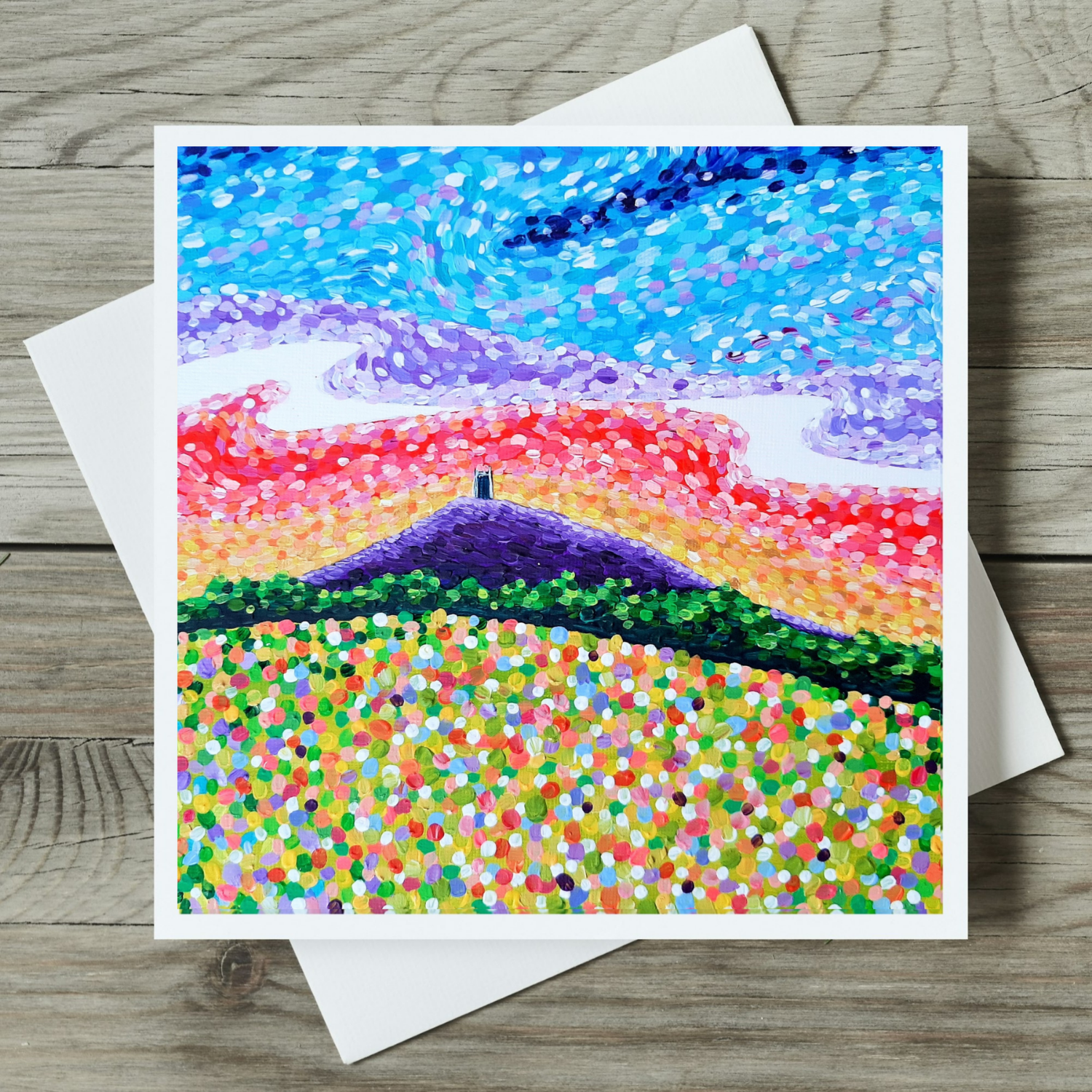 Colourful abstract landscape painting of Glastonbury Tor on a wooden surface