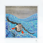 Illustration of a puffin flying over water with fish, framed by a white border.