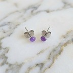 Purple resin stud earrings on a marble surface