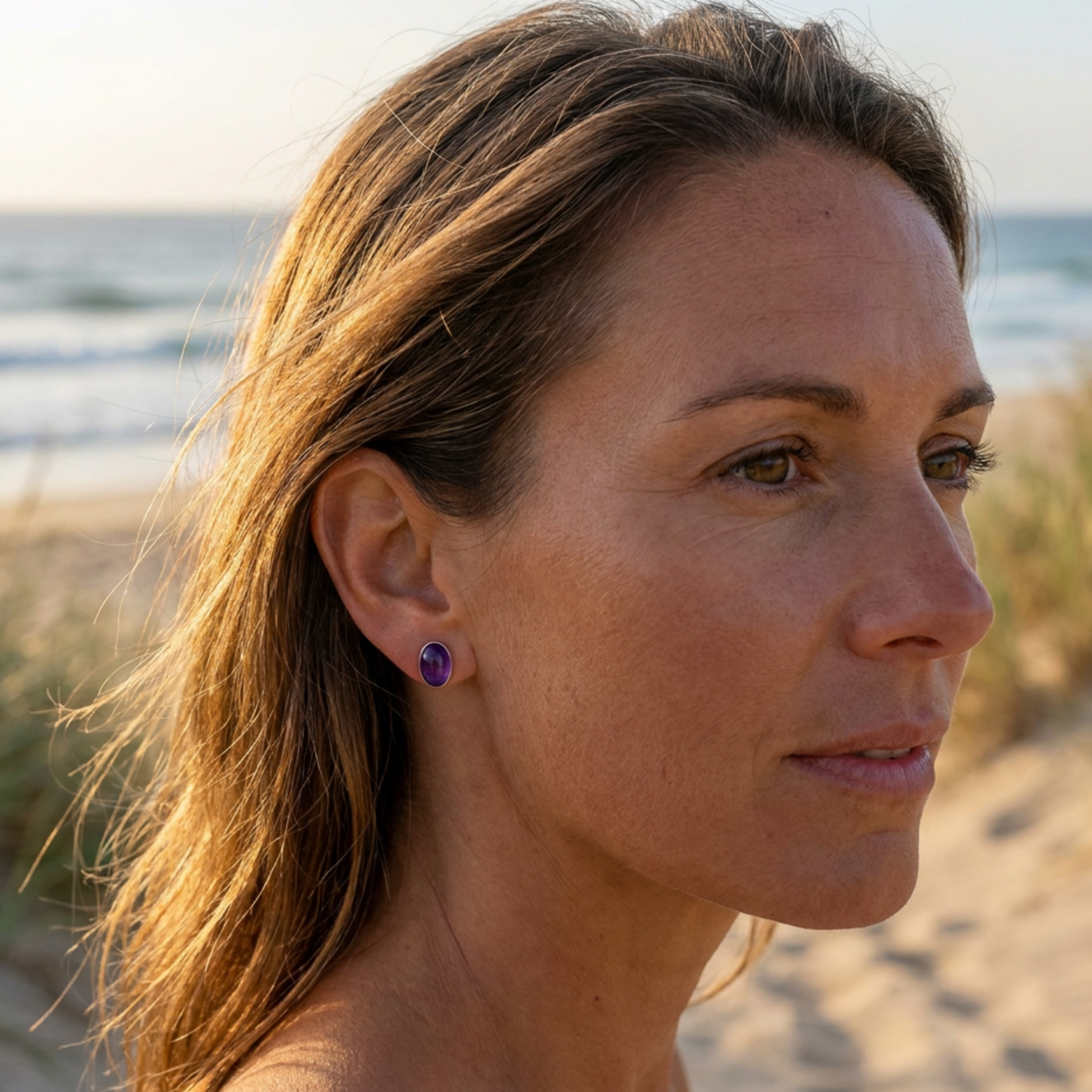 Woman with purple earrings on a beach
