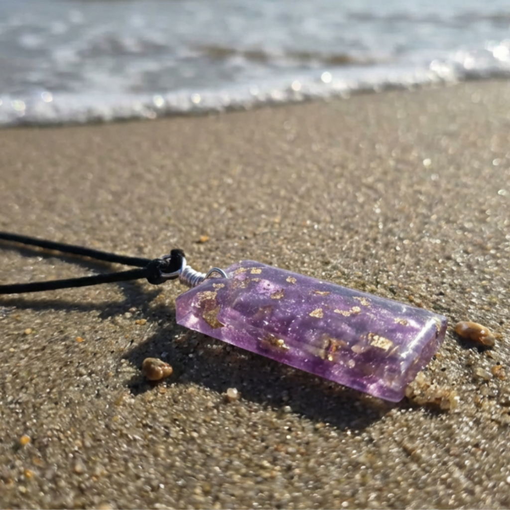 Purple pendant on a sandy beach with ocean waves in the background
