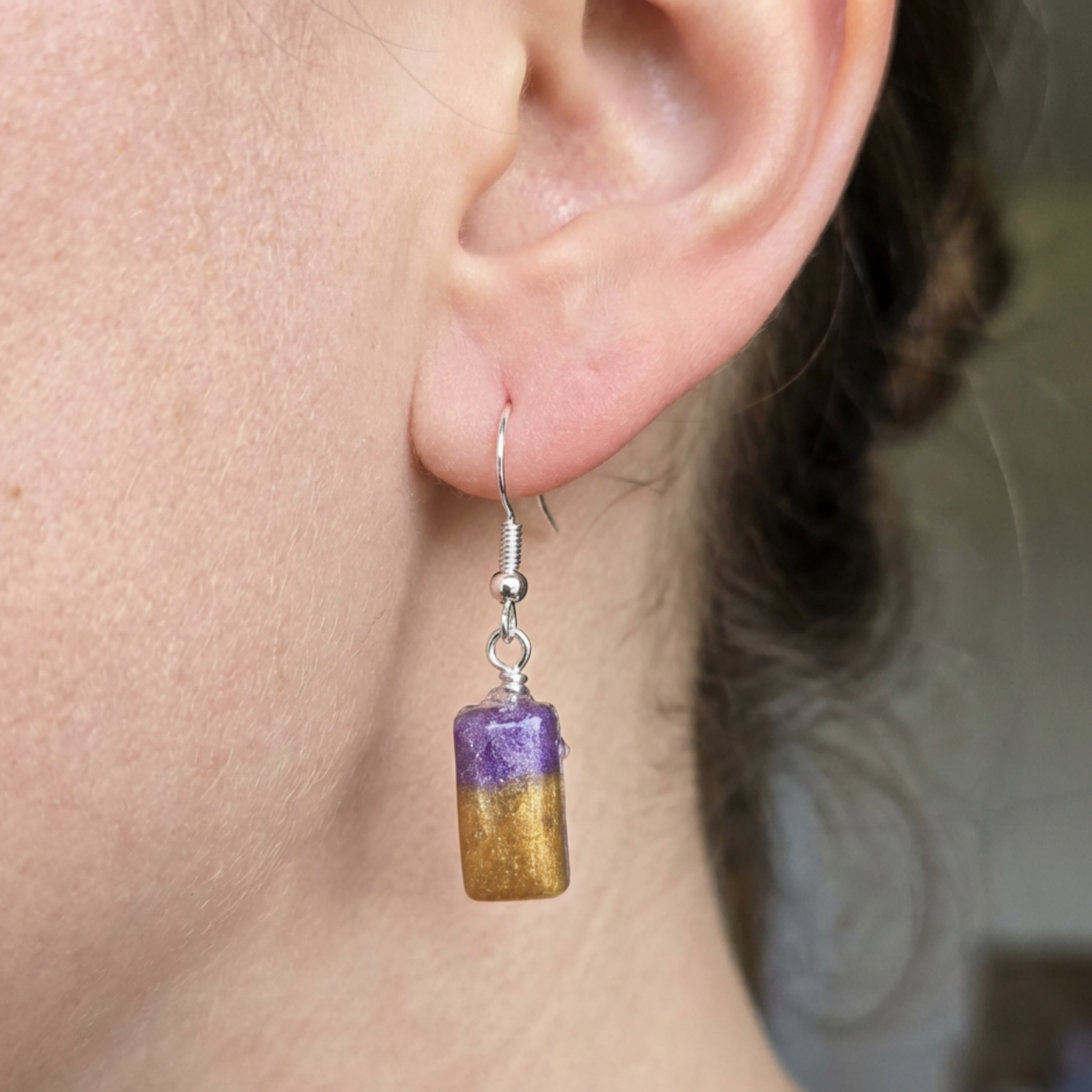 Model wearing purple and gold rectangle drop earrings