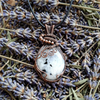 Necklace with a white stone pendant on a bed of lavender flowers