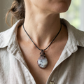 Necklace with a rainbow moonstone copper wire wrapped pendant worn by a person, close-up of the necklace.