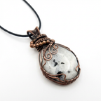 Necklace with a pendant featuring a white rainbow moonstone stone and copper wire wrapping on a white background
