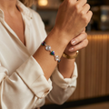 Close-up of a person wearing a colorful bracelet on a blurred background