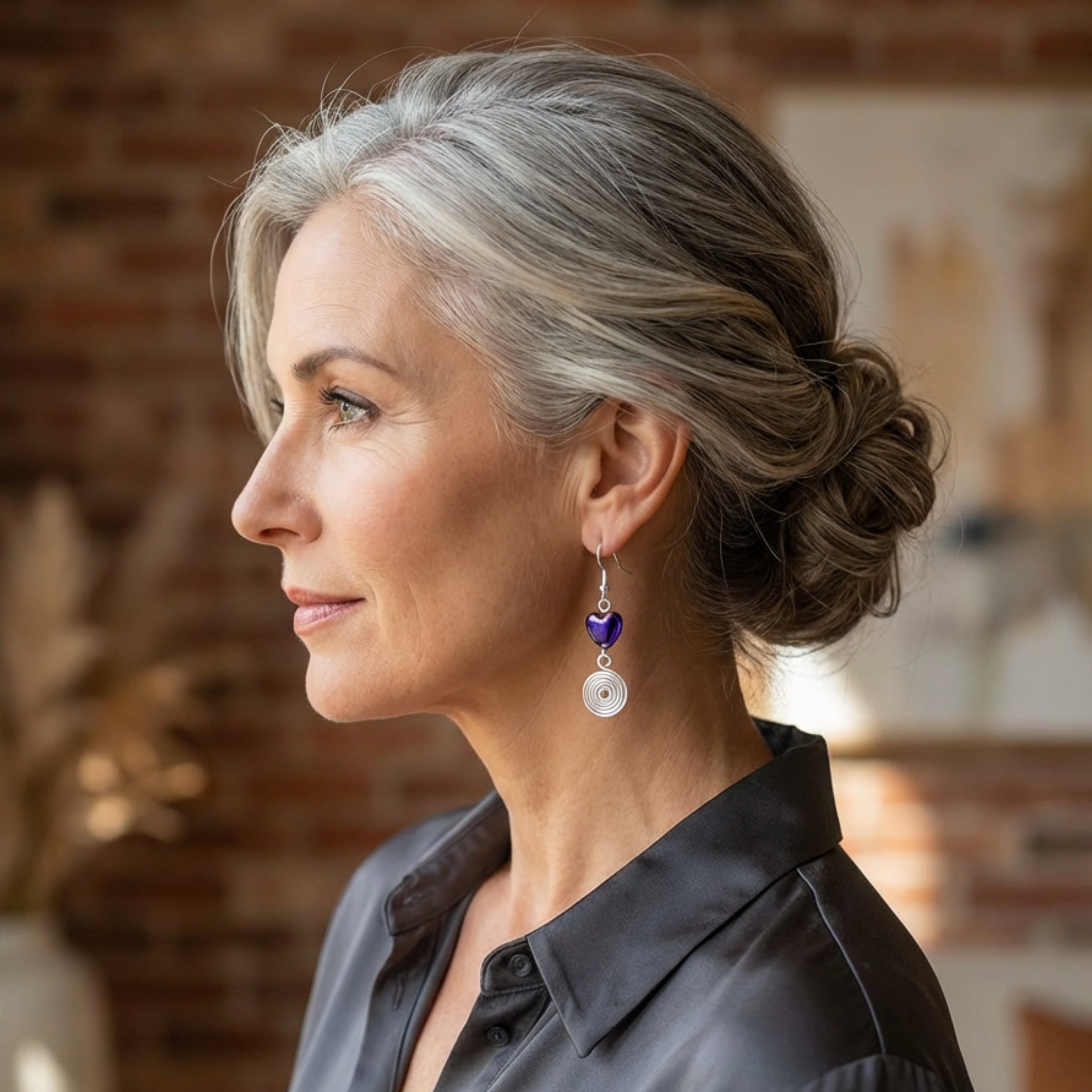 Woman with styled hair and earrings in a blurred indoor setting