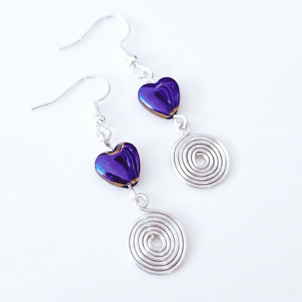 Earrings with purple heart-shaped beads and silver spiral designs on a white background